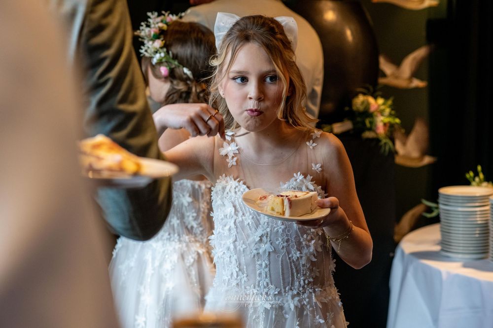 Guests holding delicate teacups at an elegant wedding reception with warm ambient lighting.