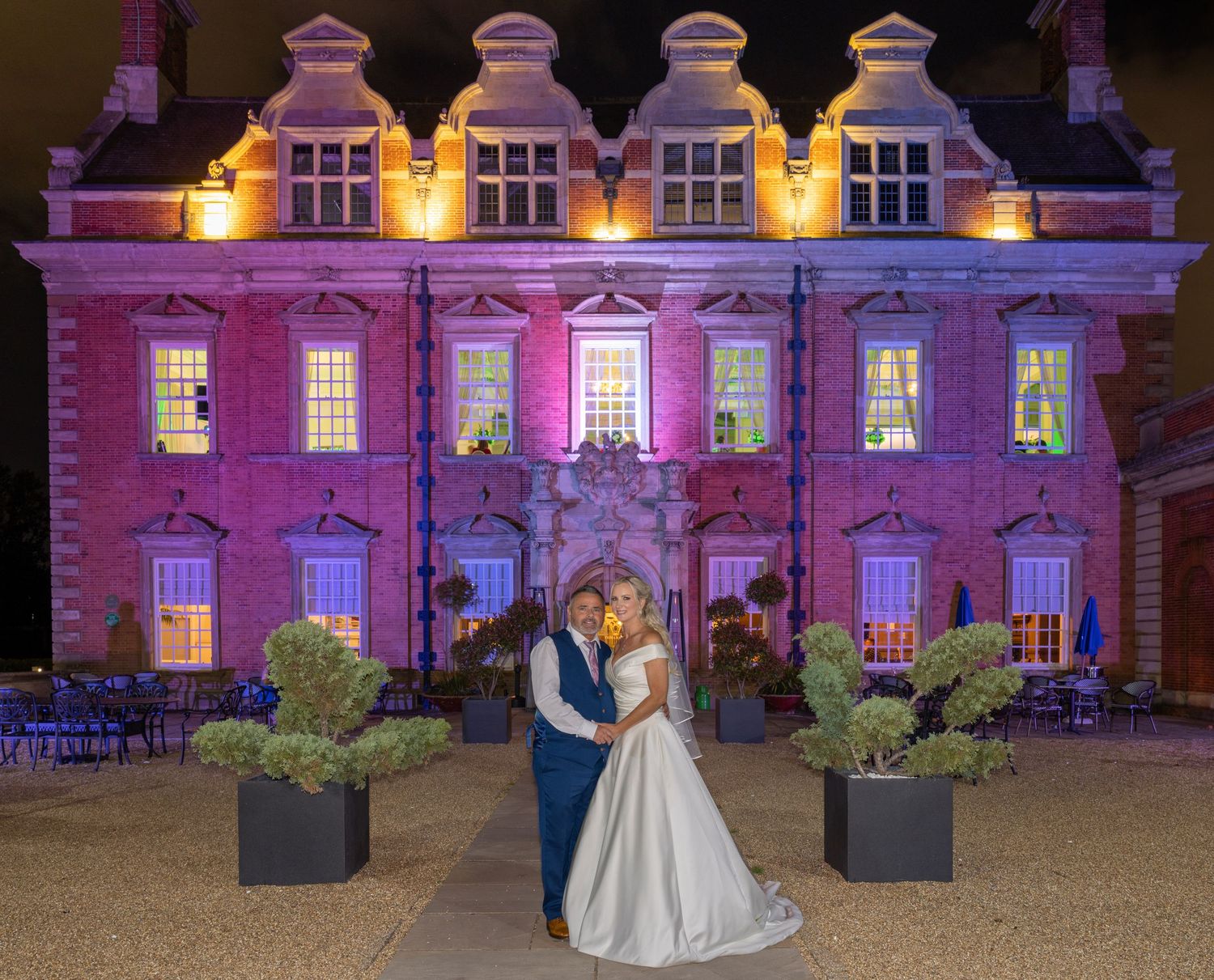 Elegant wedding couple at dusk in front of a grand illuminated mansion with colorful uplighting. Acklam Hall, Middlesbrough Casual Captures