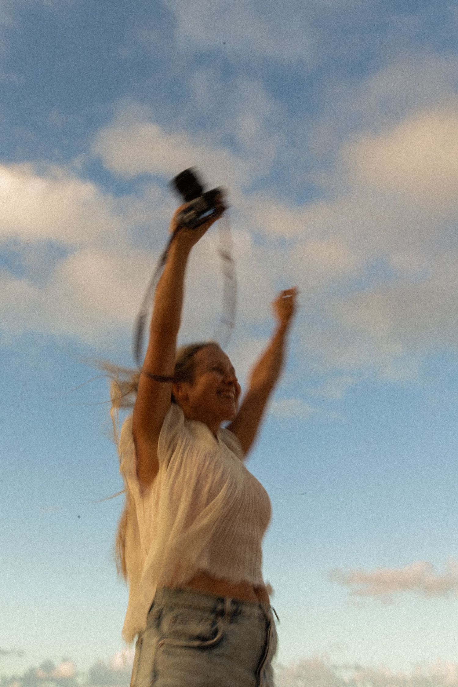 Photographer jumping on a sandy North Shore Oahu beach at sunset.