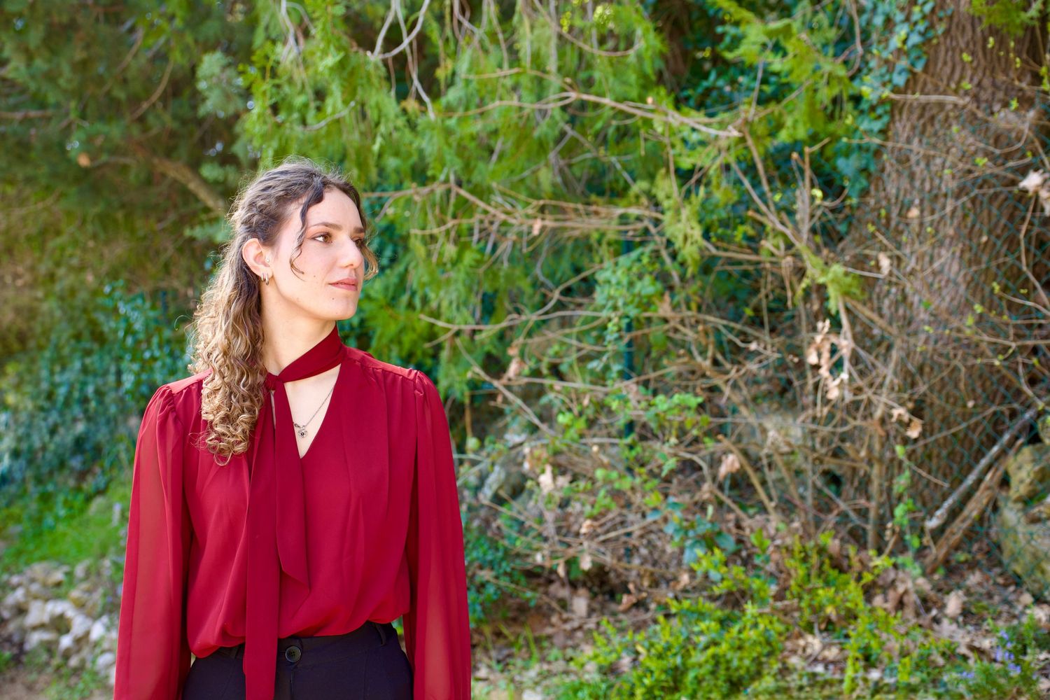 Marraine en robe rouge en séance maternité à Fuveau, portrait extérieur en lumière naturelle en Provence.