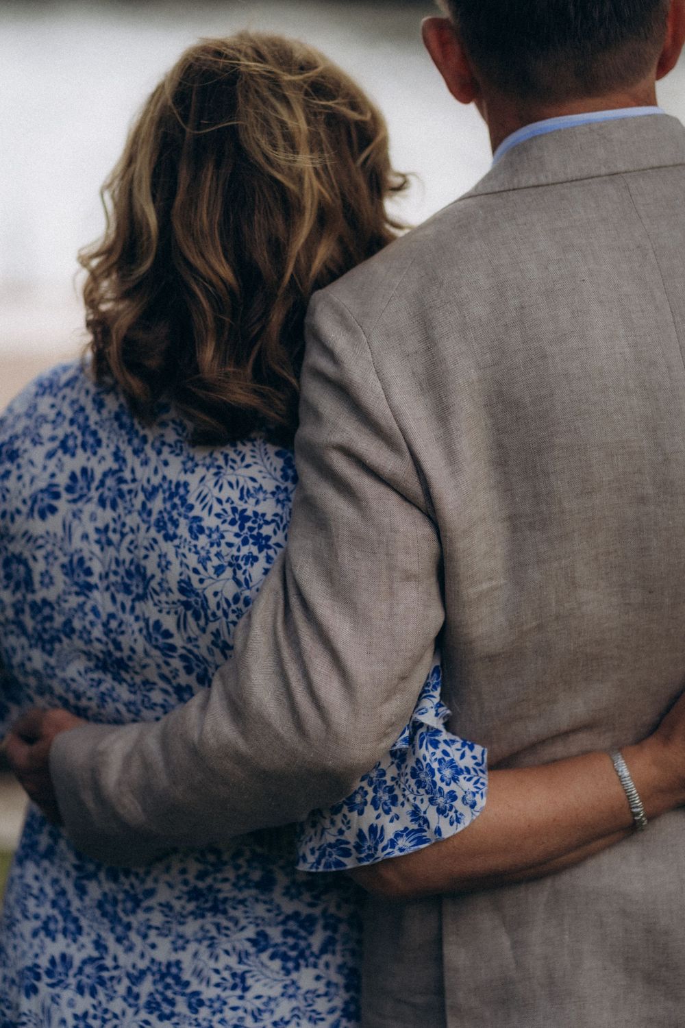 Parent couple embracing from behind during an intimate documentary wedding moment of their child