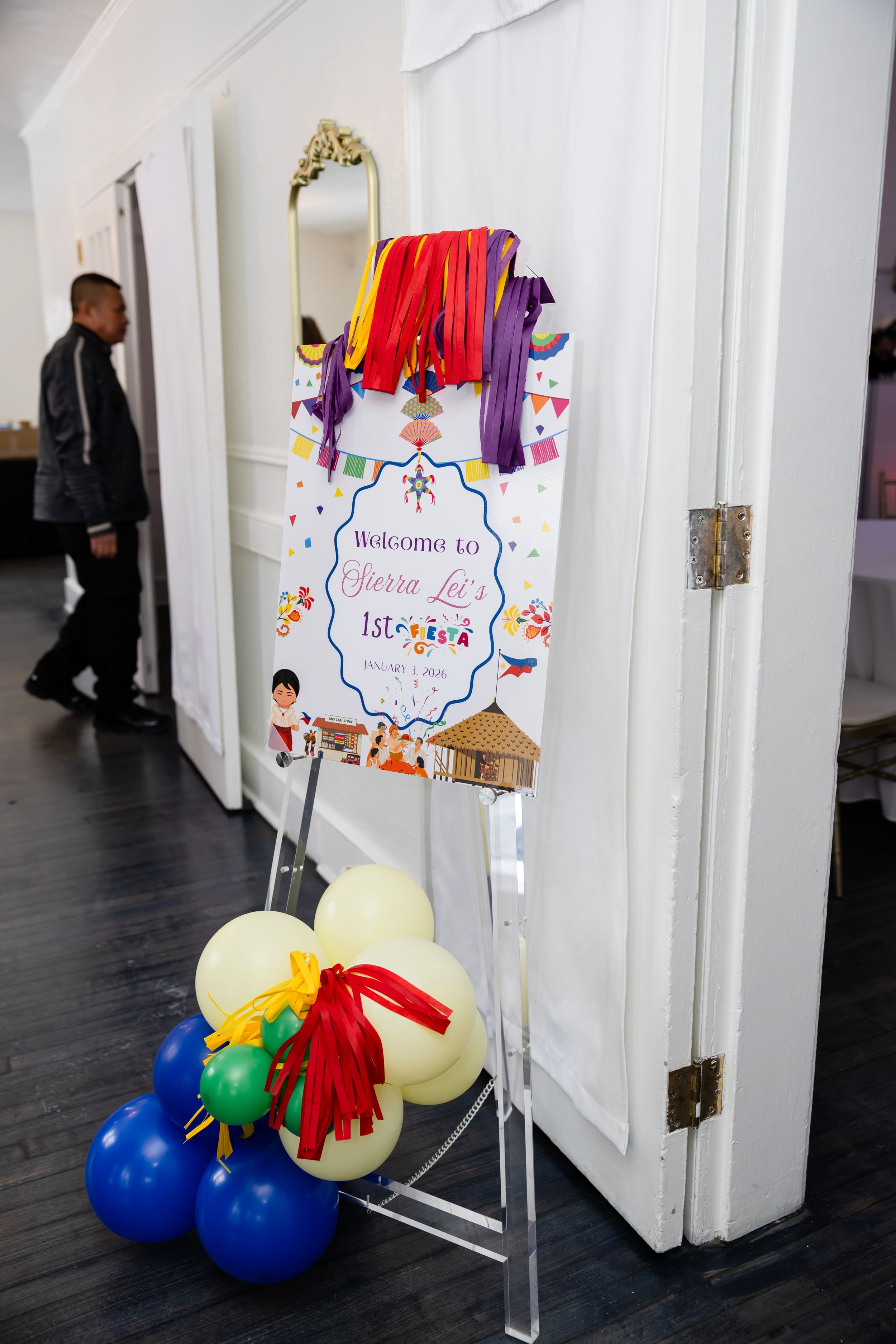 Colorful Fiesta-themed welcome sign on easel with balloon arrangement for Sierra's Isleeta birthday party celebration.