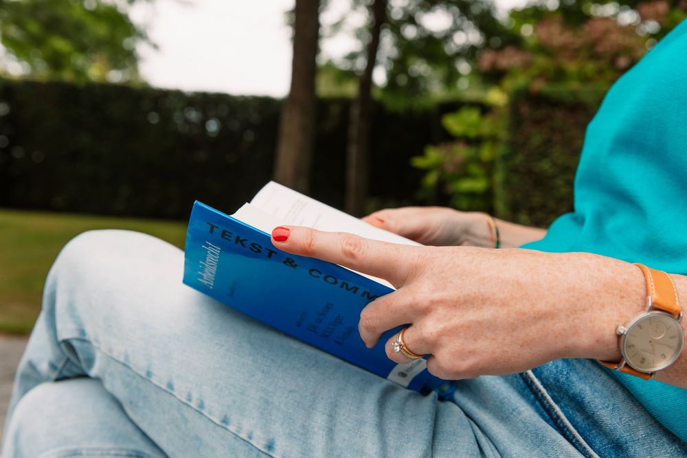 Person using digital devices while sitting outdoors.