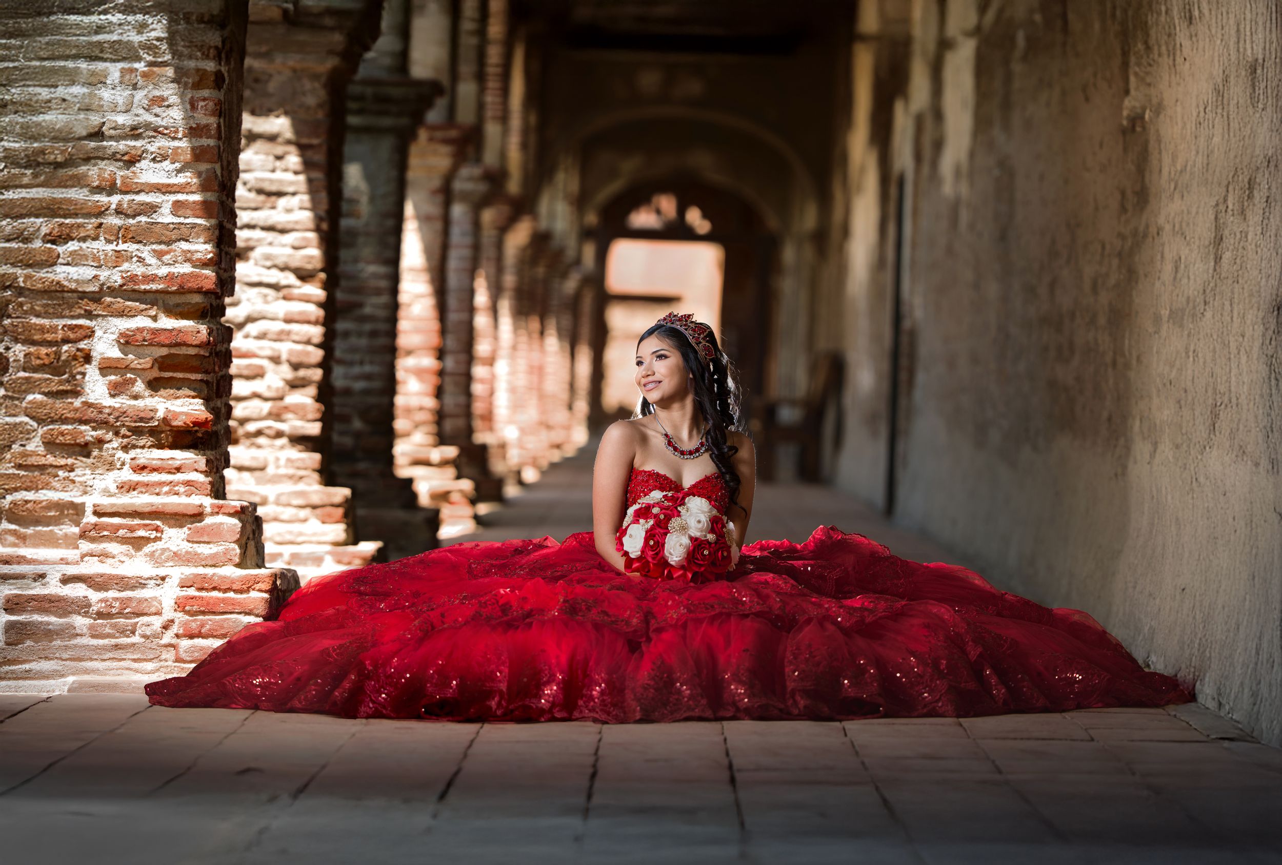 A dramatic series of photos showing a figure in a flowing red dress moving through an arched stone passageway.