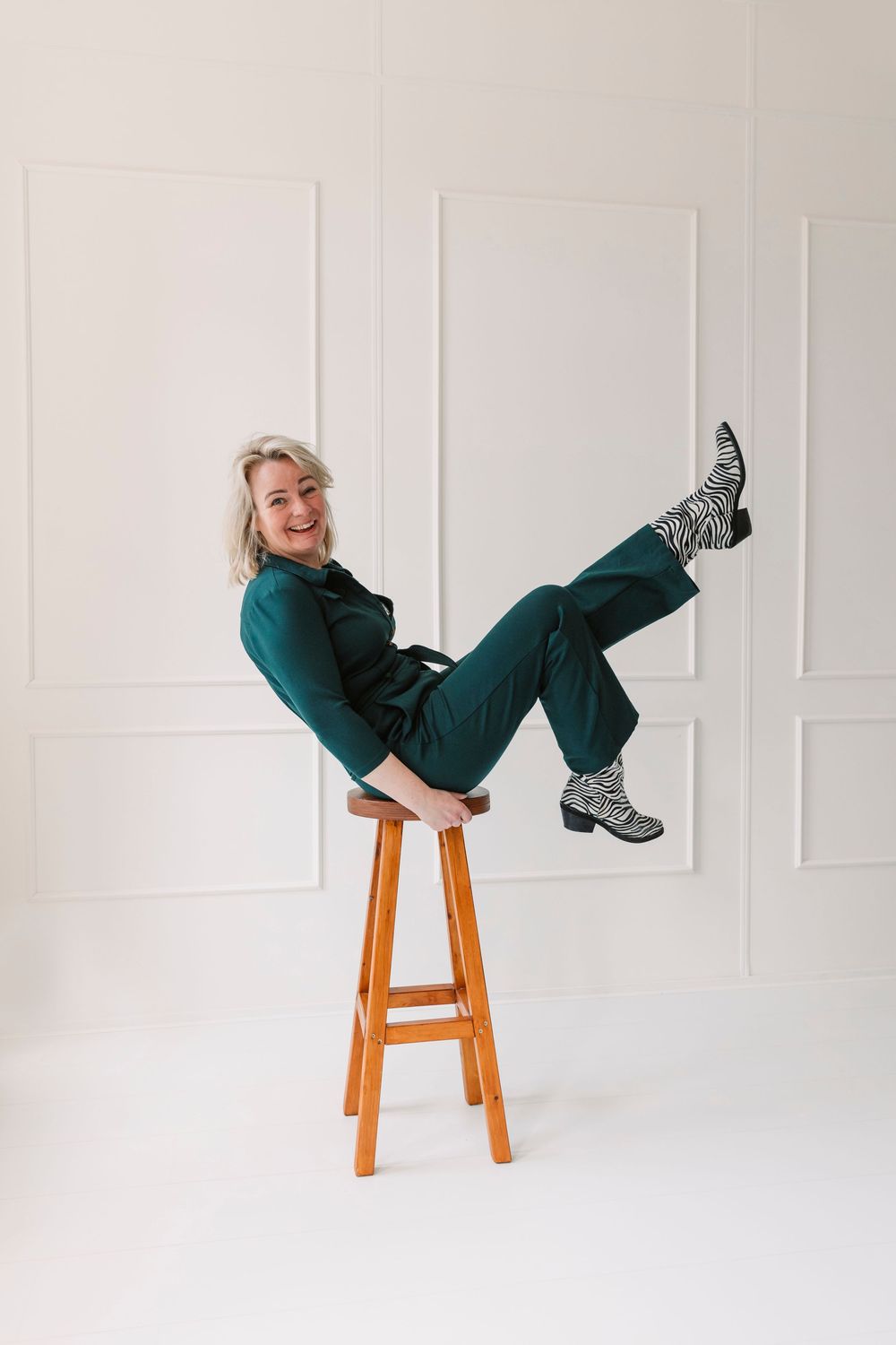 Playful poses on a wooden stool against a white backdrop showing movement and energy.