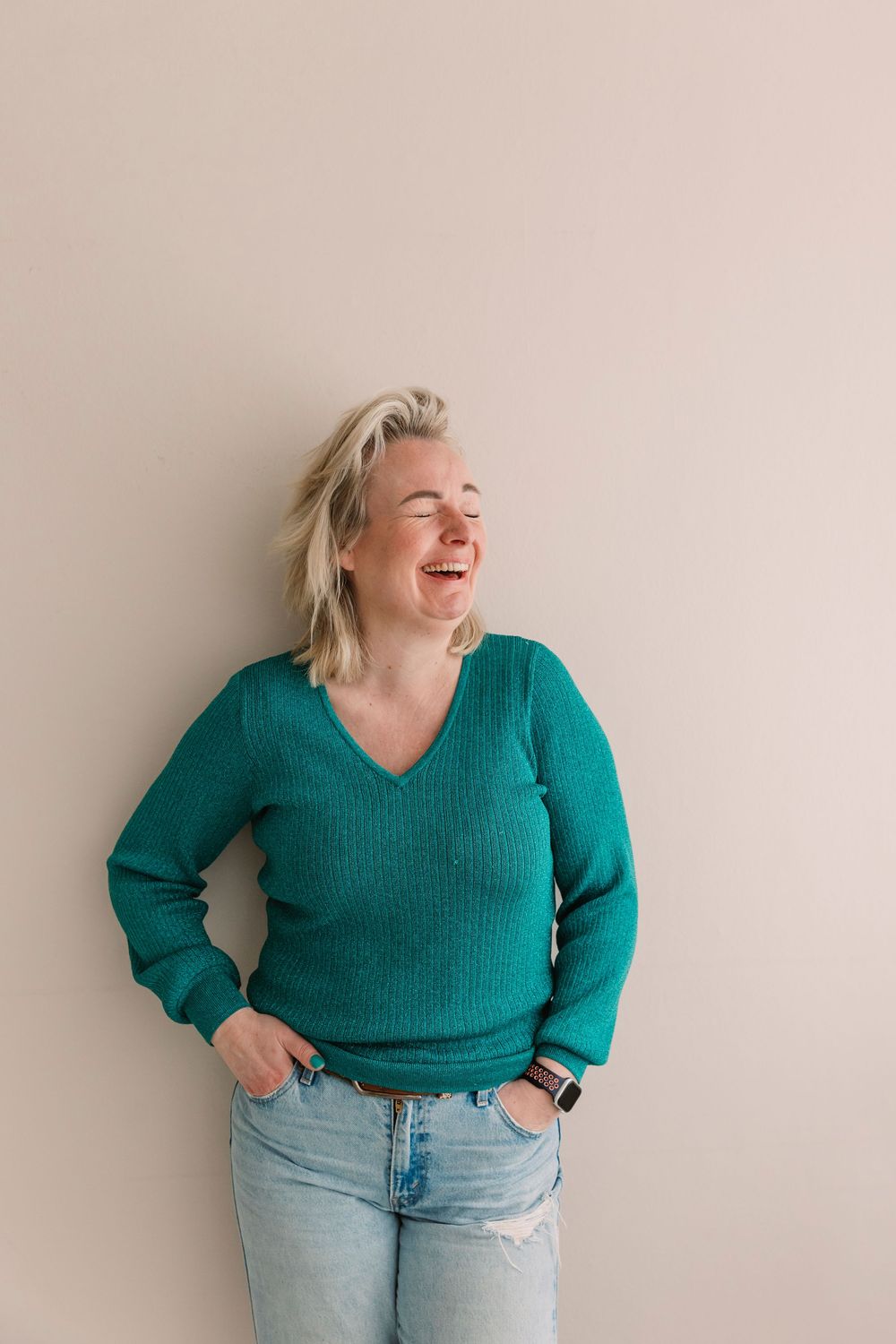 Candid moments in teal sweater and jeans against neutral background.