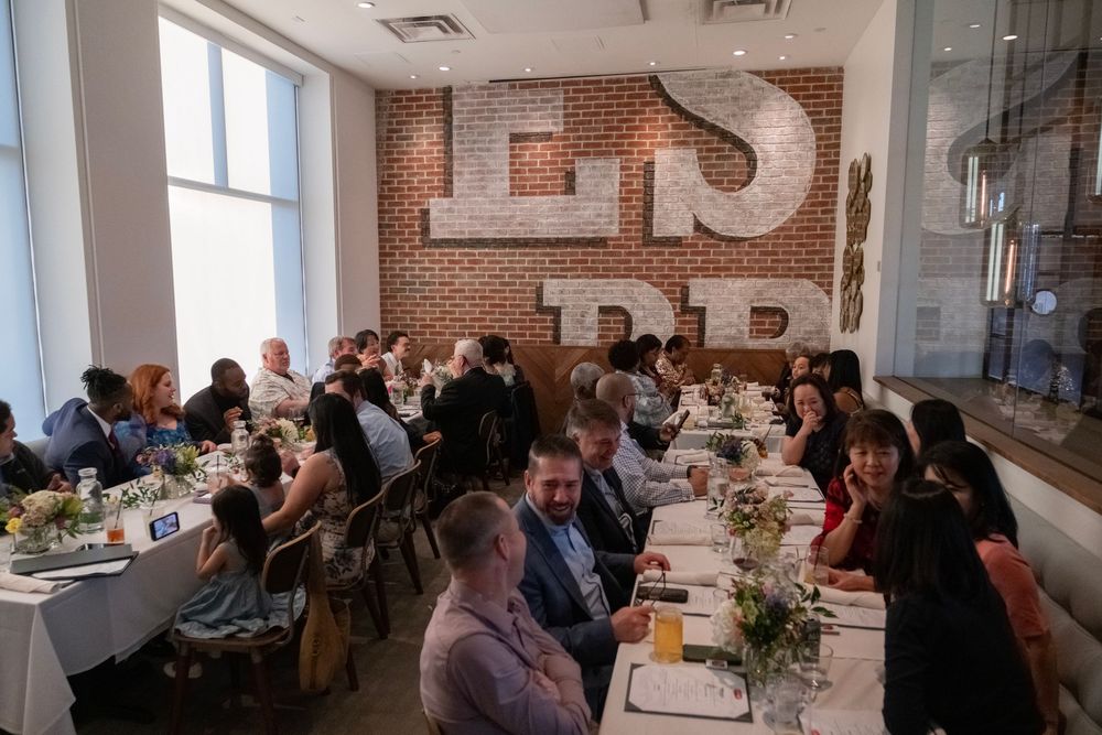 People gathered in a modern office space with exposed brick walls for a meeting or presentation.