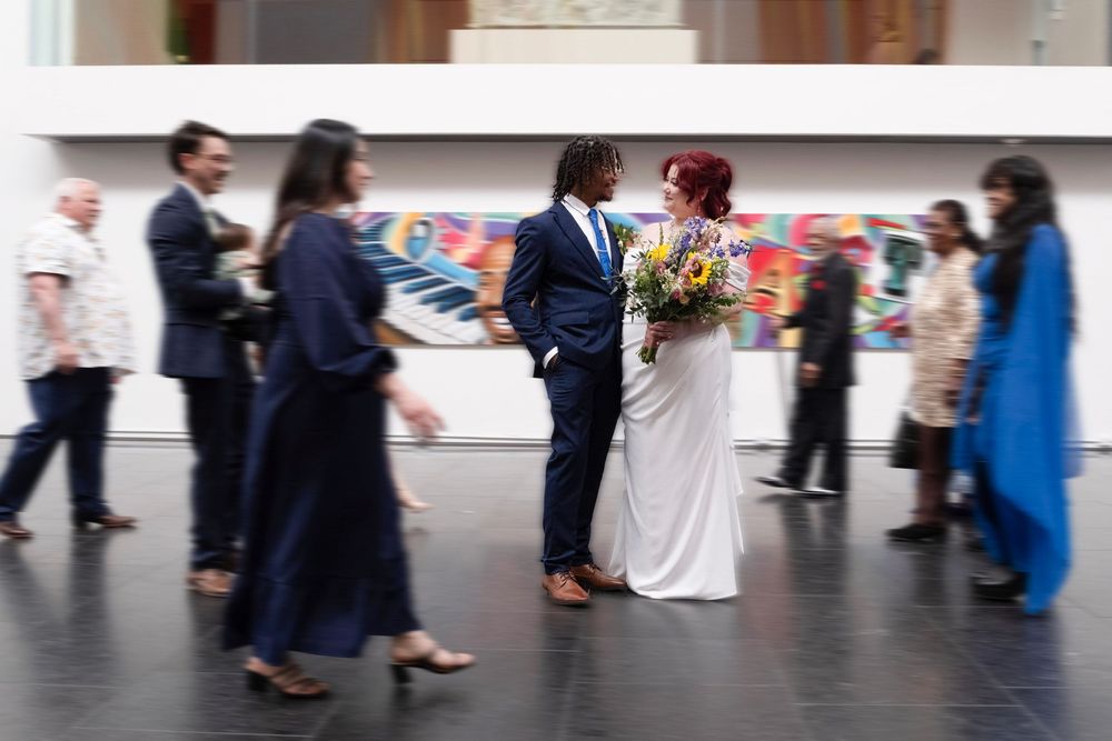 Event guests mingling in a spacious venue with colorful wall art and modern decor.