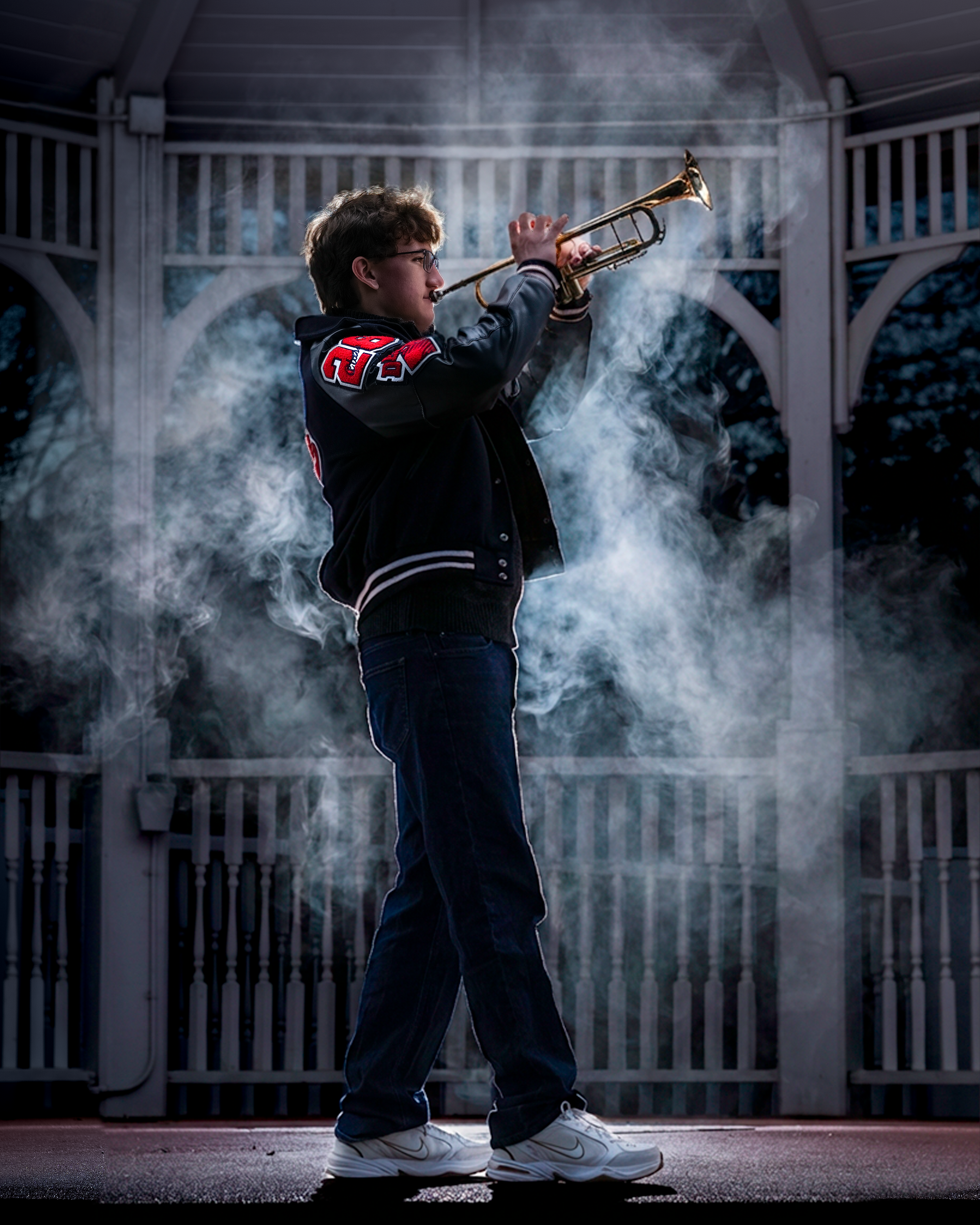 Dancer performing in front of a white gazebo with smoke effects creating a dramatic silhouette in low light.