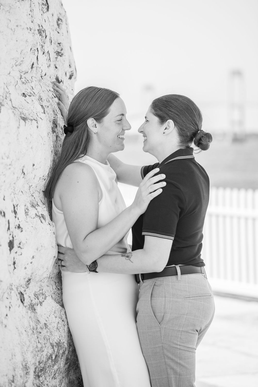 A romantic black and white photo of two people sharing an intimate moment against a white background.