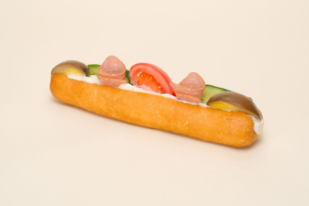 Single hot dog with toppings photographed from different angles on beige background.