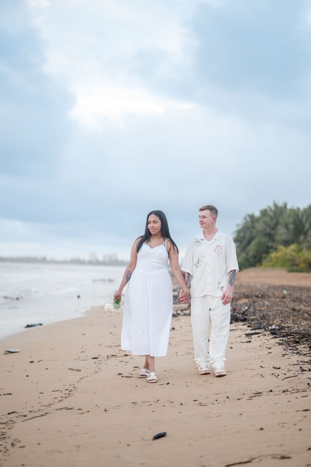 Couple walking along shoreline during engagement photos in Rio Grande Puerto Rico at Wyndham Rio Mar