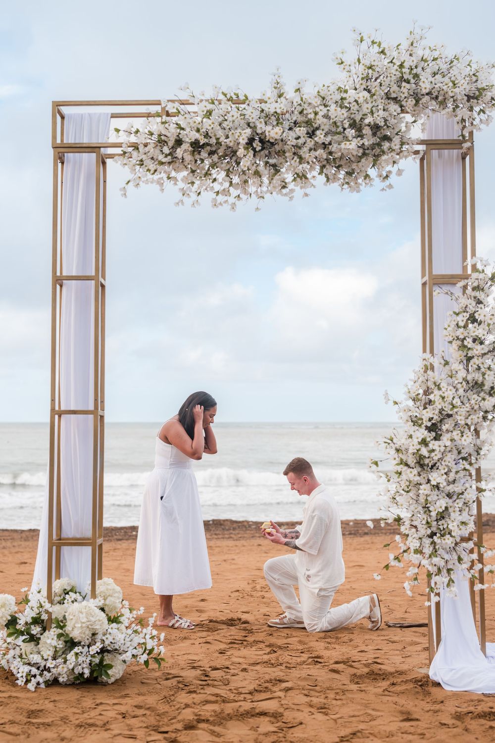 Couple holding hands under wedding style arch during engagement photos in Rio Grande Puerto Rico