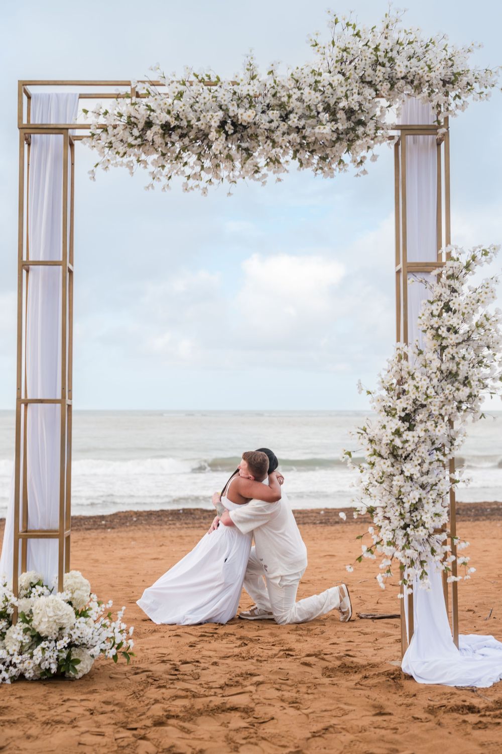 Bride sitting under floral arch during engagement session at Wyndham Rio Mar Puerto Rico