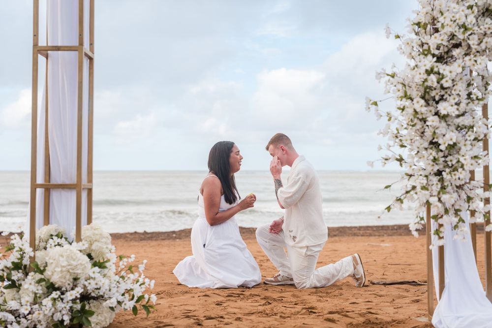 Couple under floral arch during engagement session at Wyndham Rio Mar in Puerto Rico