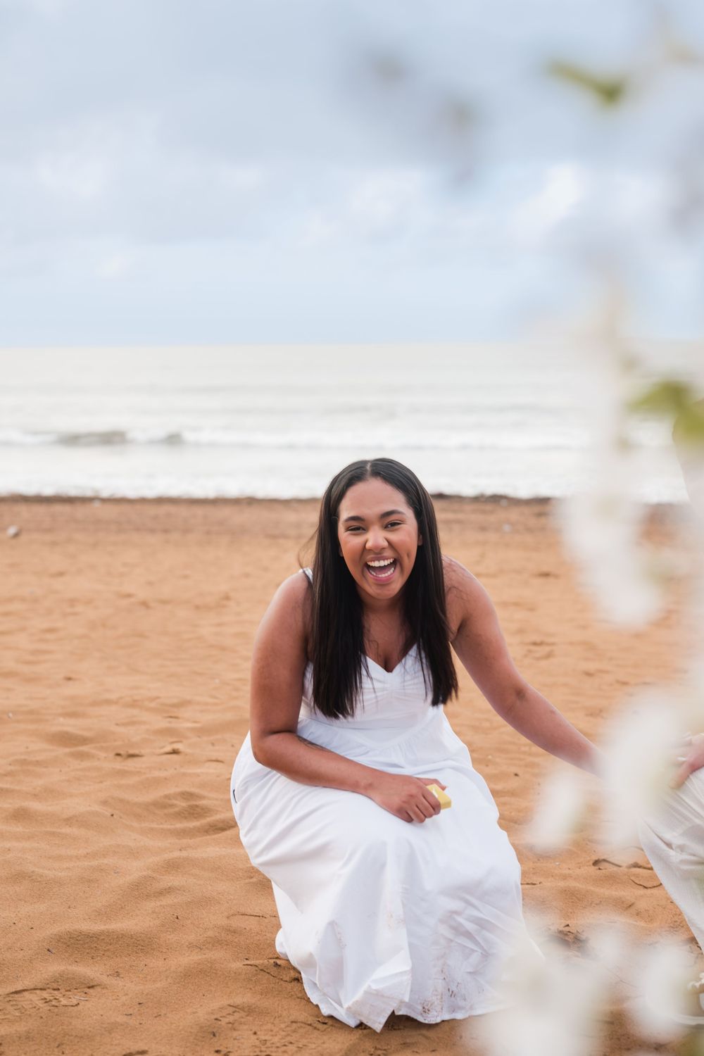 Bride sitting on beach during engagement session at Wyndham Grand Rio Mar Puerto Rico