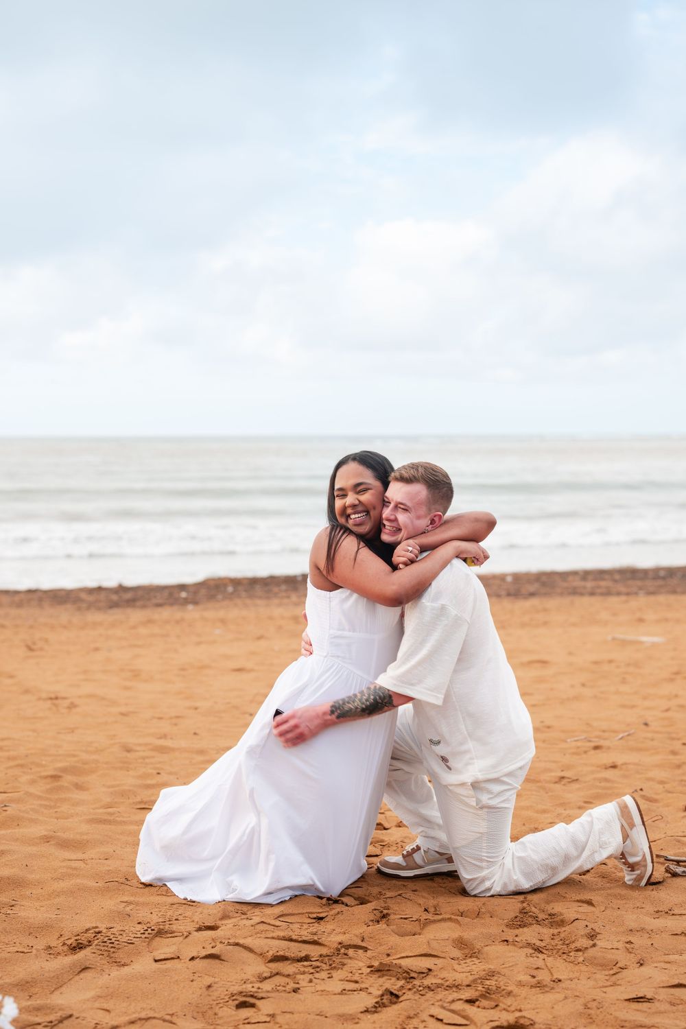 Couple sitting together on sand during engagement photos at Wyndham Rio Mar in Rio Grande Puerto Rico