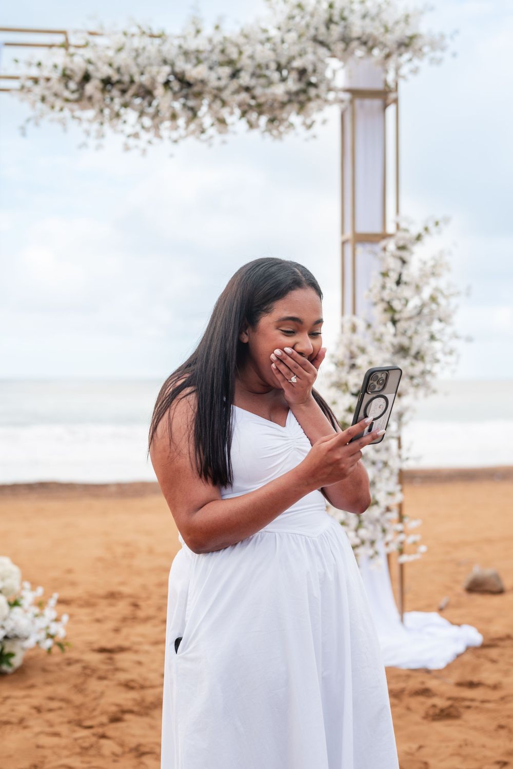 Bride standing near floral arch during engagement session at Wyndham Grand Rio Mar beach in Puerto Rico
