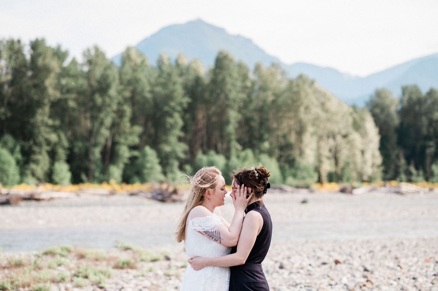 A couple shares an intimate moment along the Cowlitz River during their elopement. Photo by Washington Elopement Photographer, Pine + Vow