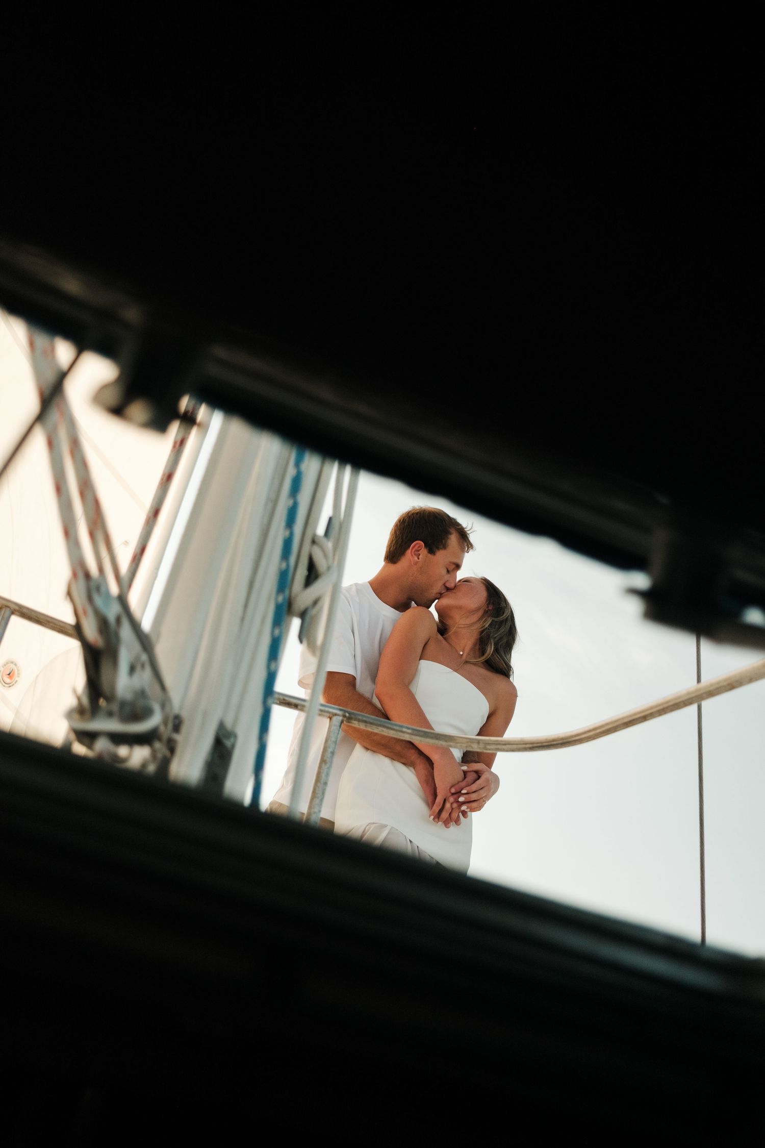 A couple in matching white outfits holding hands on a sunny day.