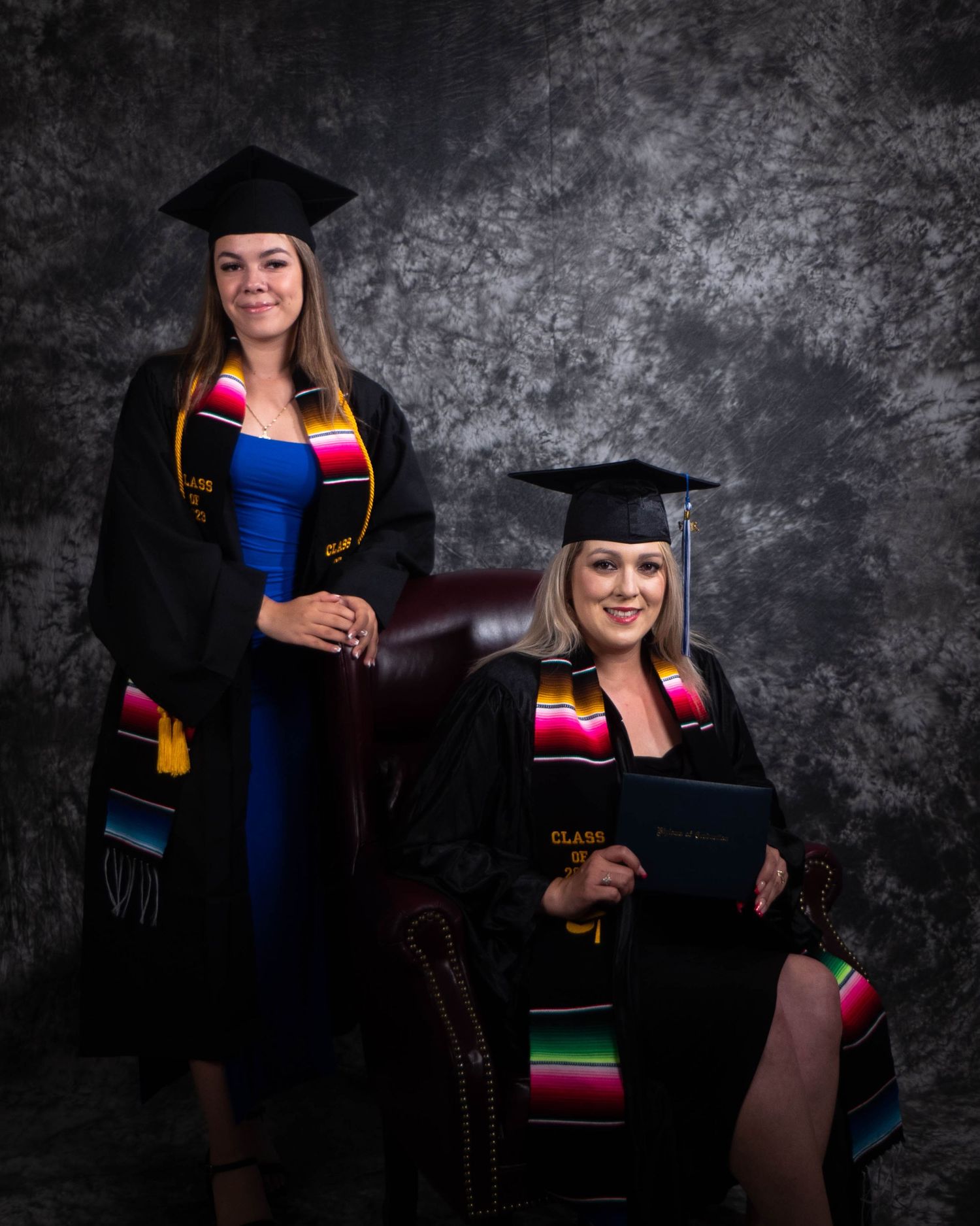 Graduation portraits showing graduates in caps and gowns with colorful stoles against dark background.