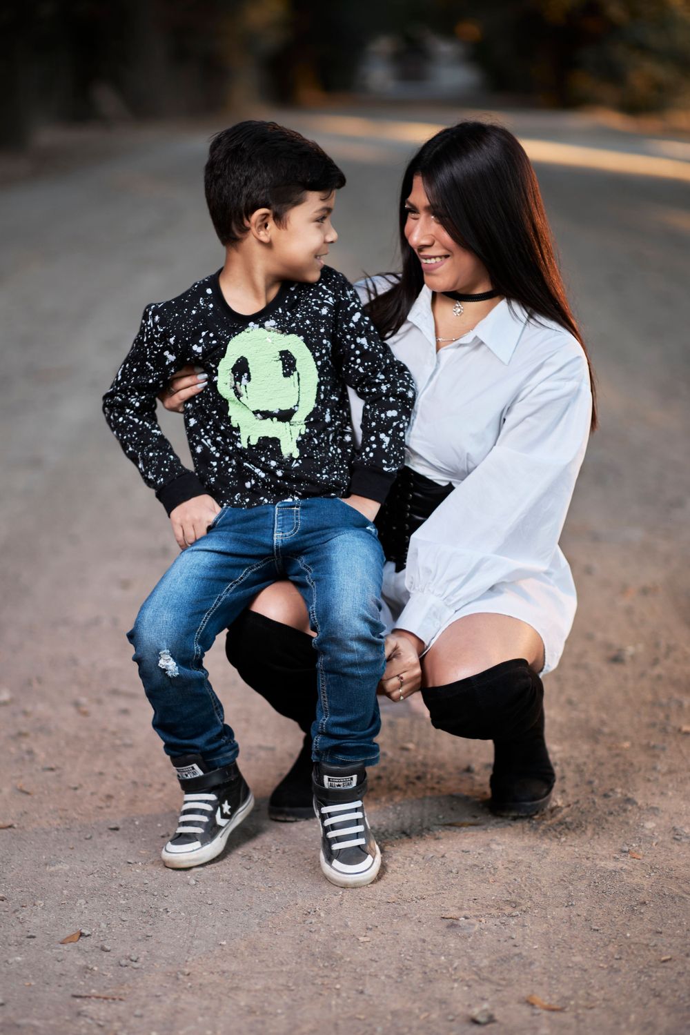 Sweet candid moment showing parent and child in casual wear sitting together outdoors.