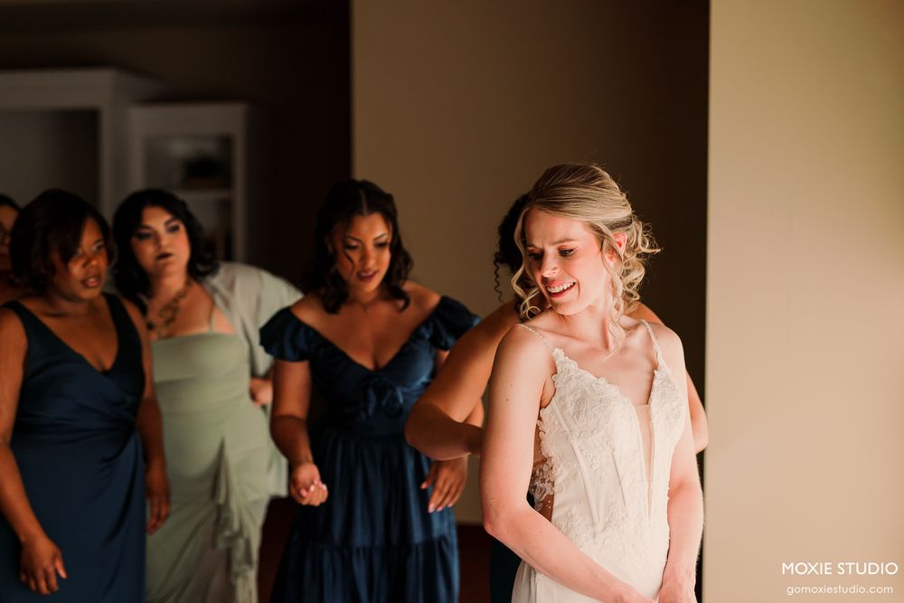 Wedding reception dance floor filled with guests celebrating and dancing in a dimly lit room.
