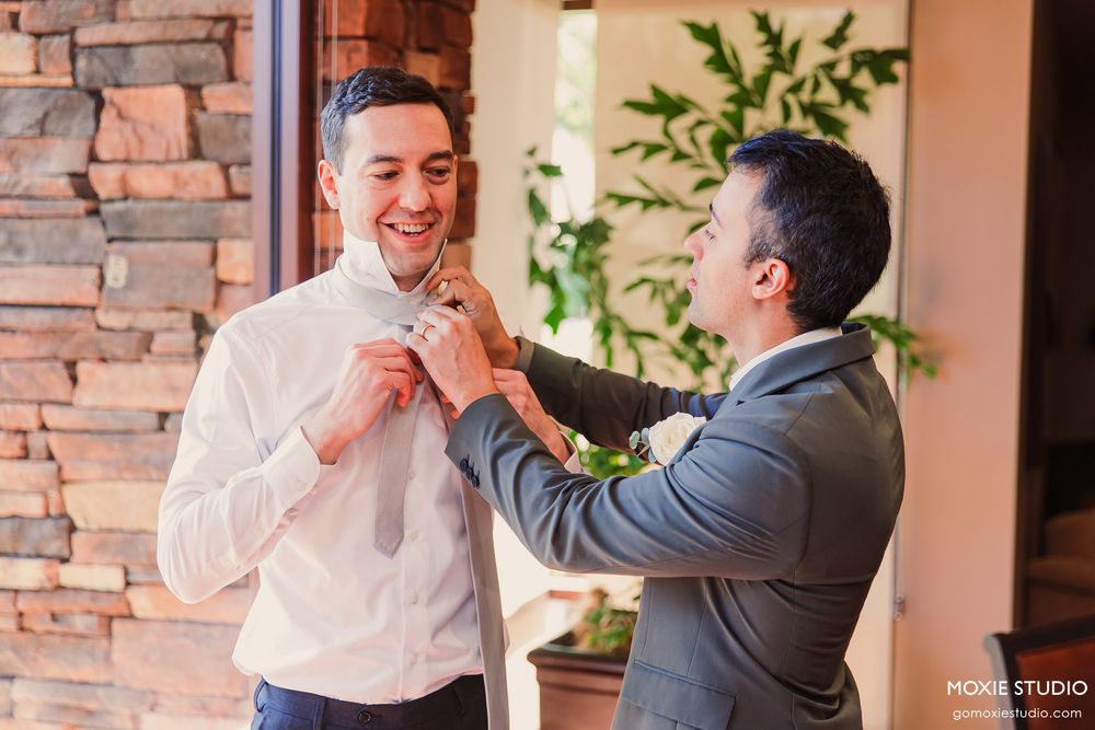 Two people sharing a joyful moment and hugging in front of a brick wall interior.