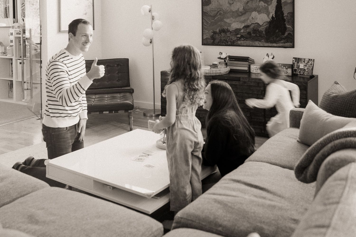 A sequence of black and white photos showing a person sitting on a couch and interacting with others in a living room setting.