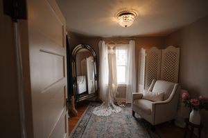 A crystal chandelier hangs from a white ceiling in an elegant hallway interior.