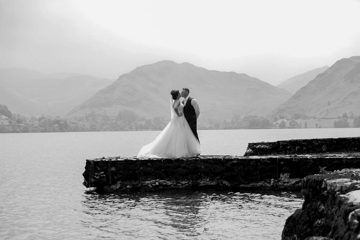 Black-and-white wedding photography montage featuring a couple silhouetted against dramatic Lake District mountain scenery.