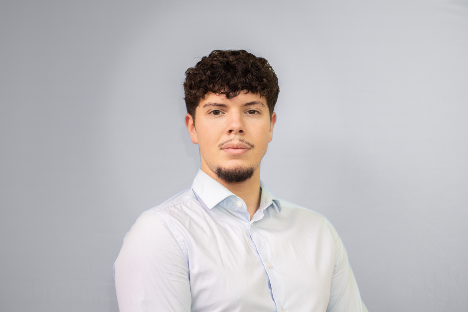 Portrett av ung mann i hvit skjorte mot grå bakgrunn, CV-foto og headshot av Prospectxmedia.