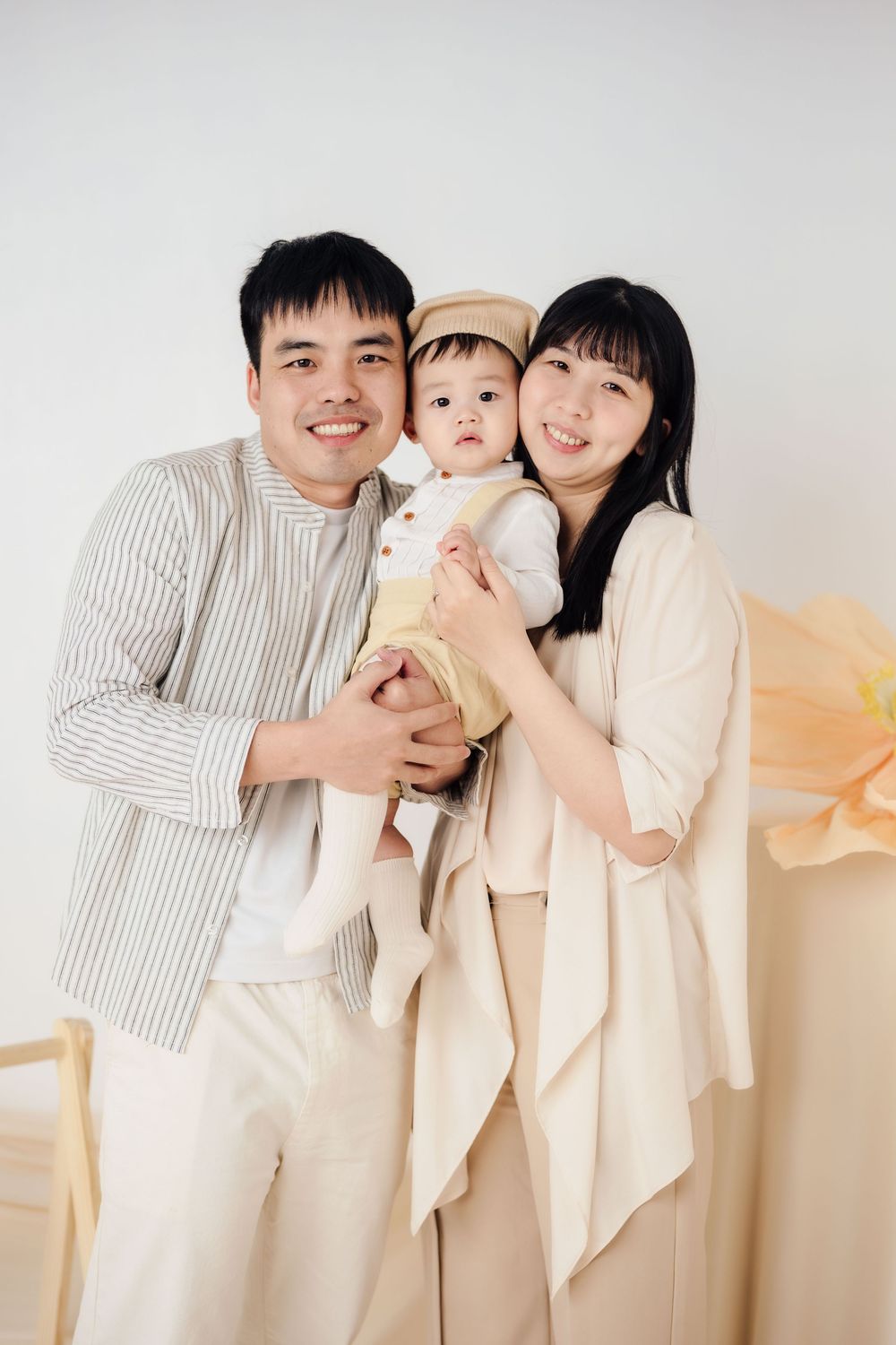 抓周寫真、全家福，渴望影像紀錄一歲寶寶抓周儀式與親子互動，透過自然光棚拍呈現溫暖氛圍，畫面包含寶寶拿取抓周物品、爬行探索與父母陪伴互動，整體風格乾淨柔和、色調溫潤，適合尋找屏東抓周寫真、全家福攝影、寶寶周歲紀念攝影的家庭參考，依照服裝而改變佈景，呈現真實自然且具故事感的家庭影像。