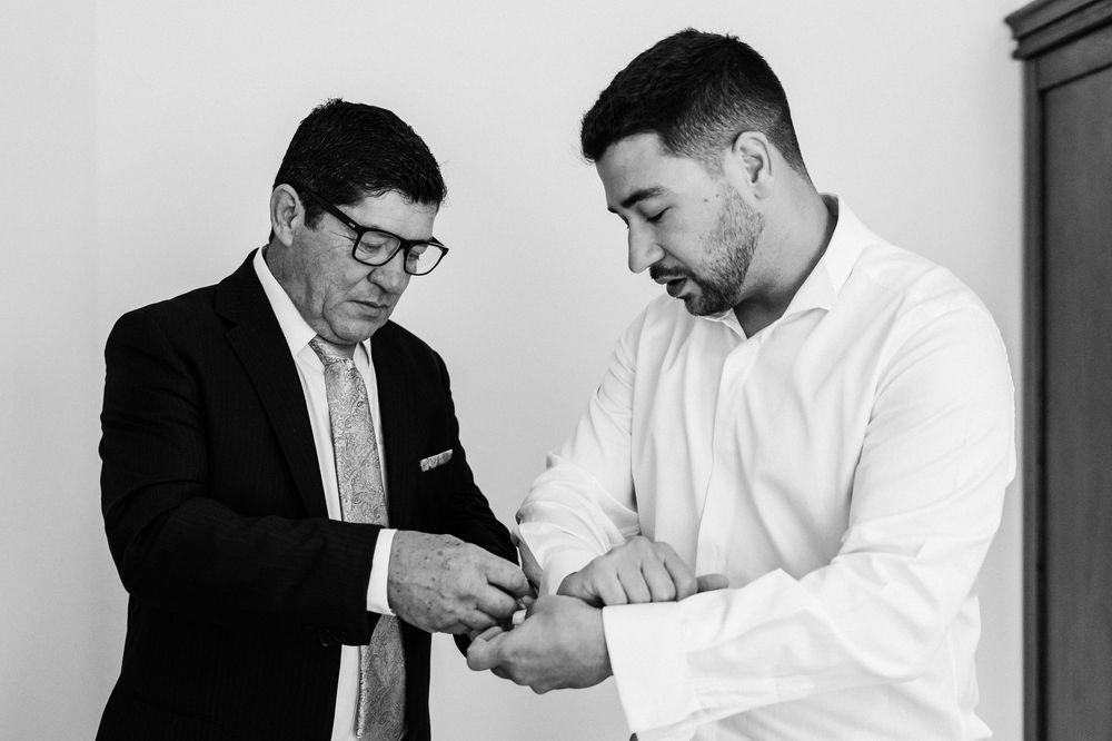 Two men in formal attire shaking hands in a professional setting.
