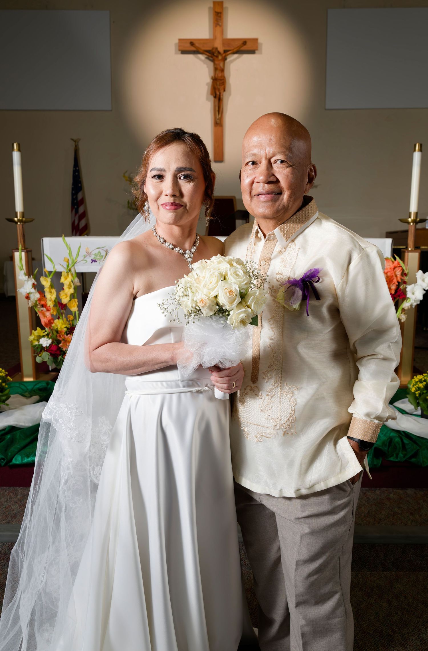 Bride and groom stand in front of altar at St. Bernadette's Church in Stockton California.