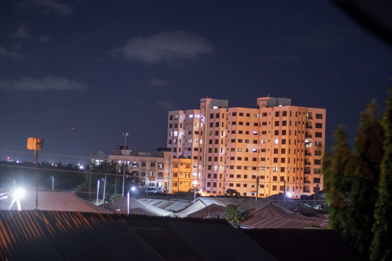 A night time photo of a storey building with variety of lights