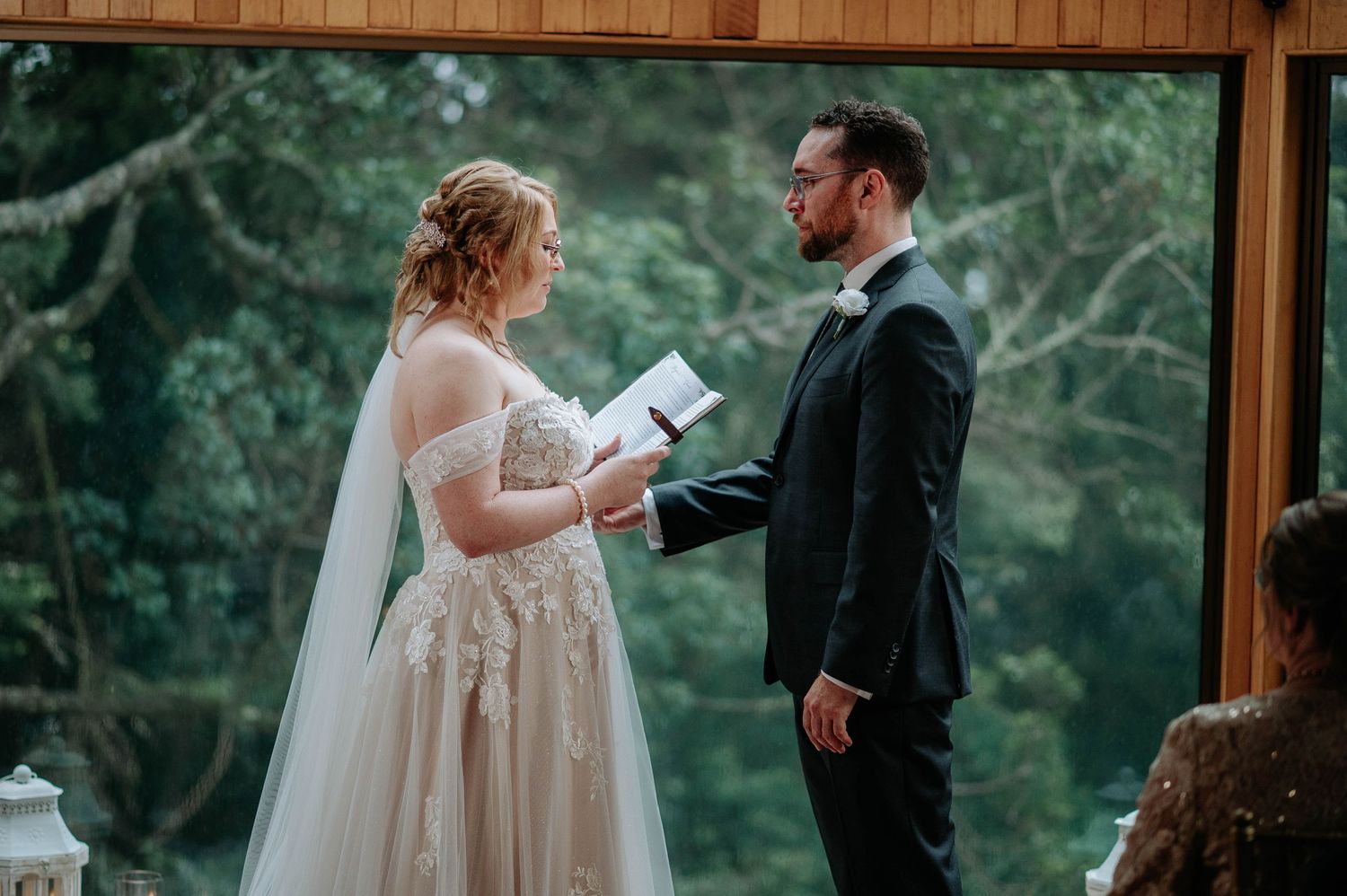 Couple sharing personal vows during intimate forest wedding ceremony.