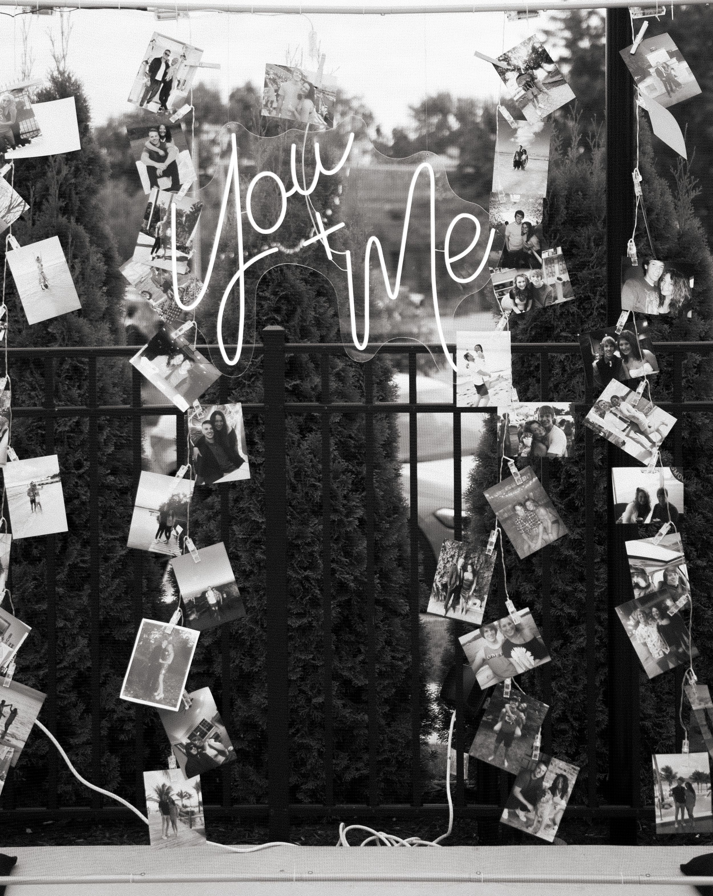 Black and white photo showing neon 'You & Me' sign with vintage photographs arranged around it on dark background.