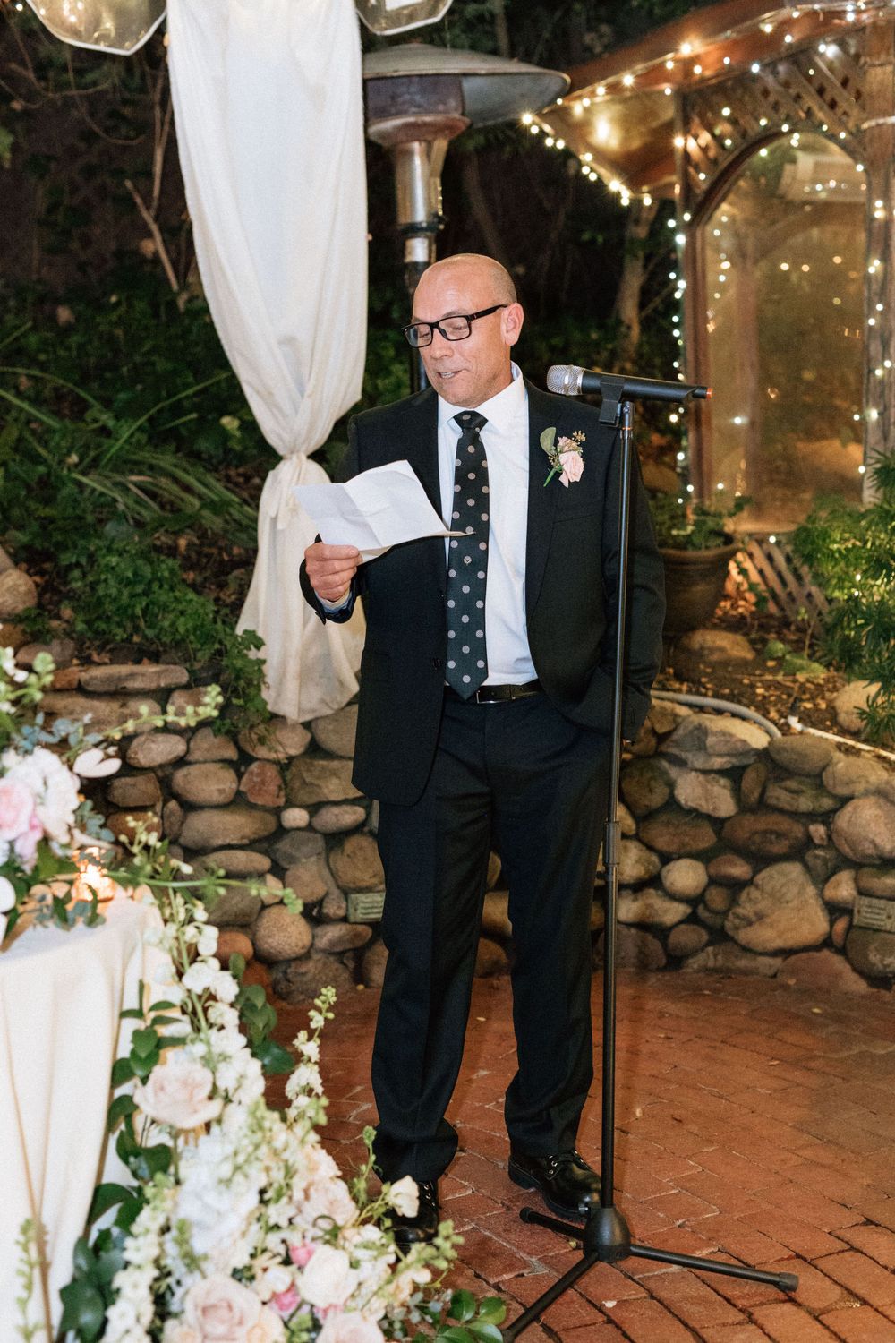 man reads speech at wedding reception