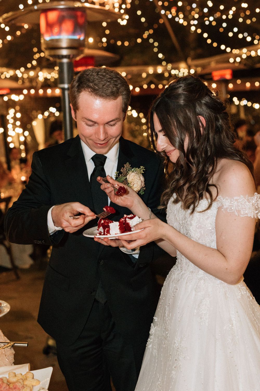 bride and groom share slice of wedding cake at their reception