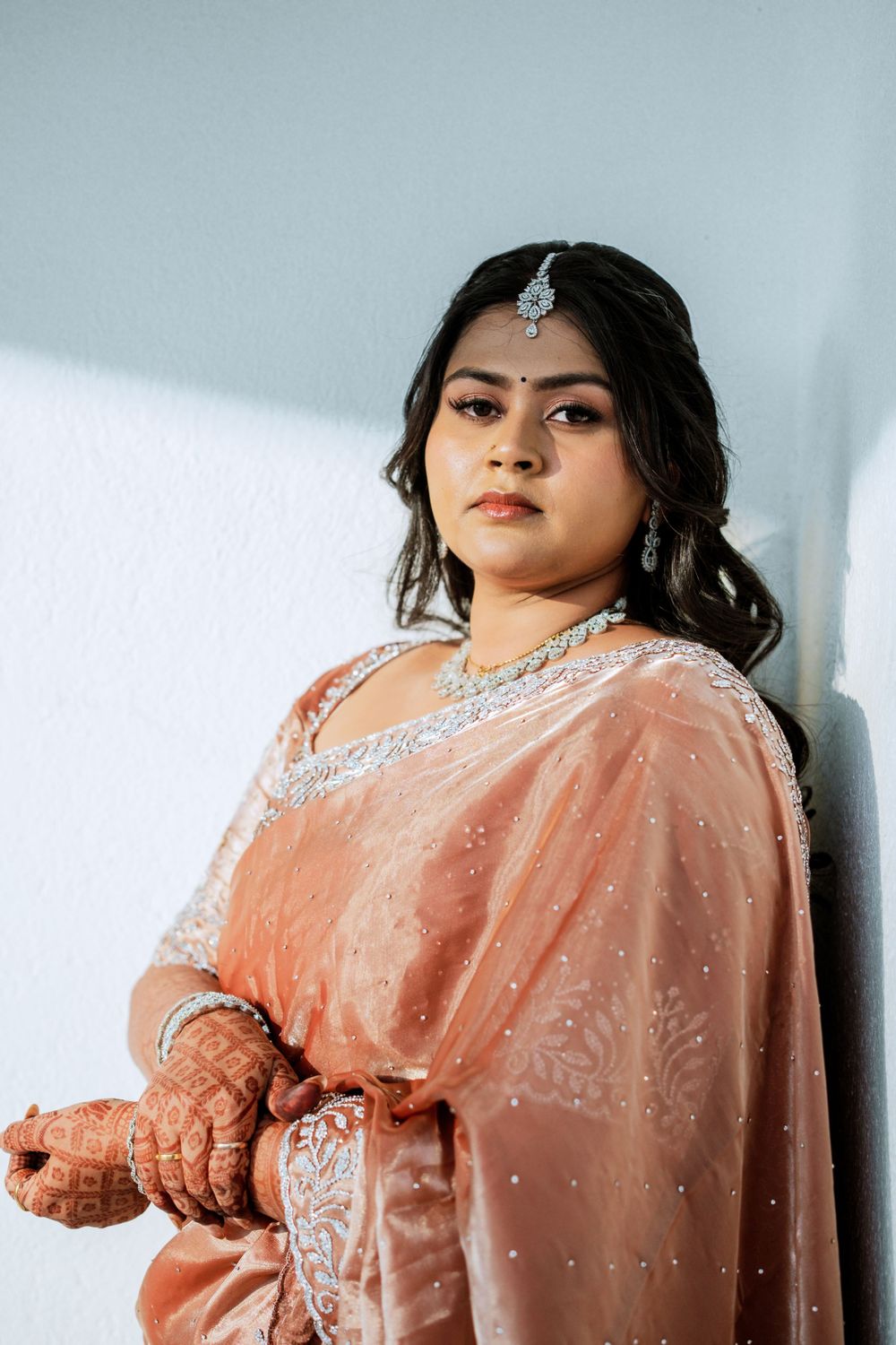 Portrait showcasing traditional Indian bridal jewelry and peach embellished saree.