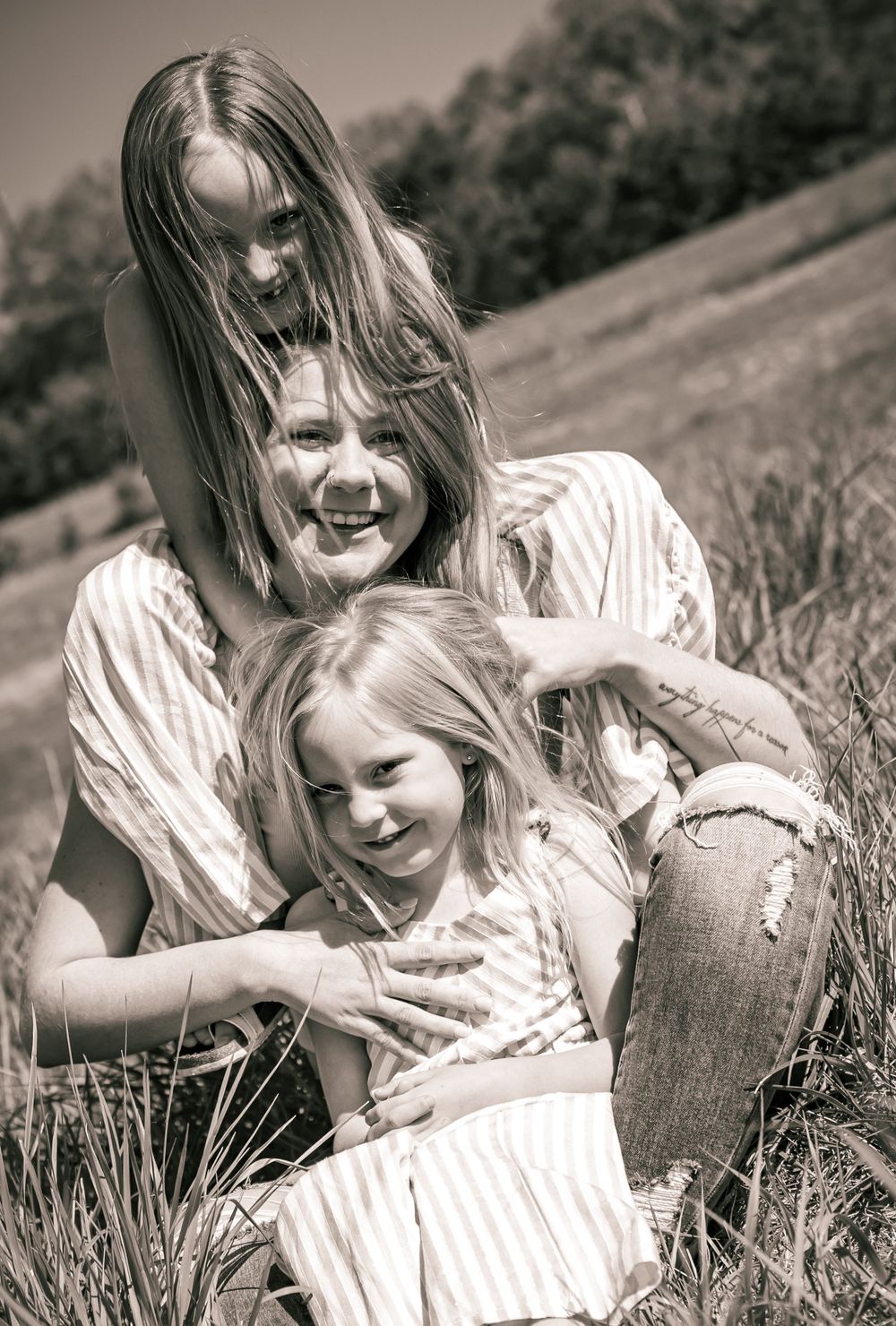 Black and white portrait of joyful playful moments captured outdoors in a grassy meadow on a sunny day.