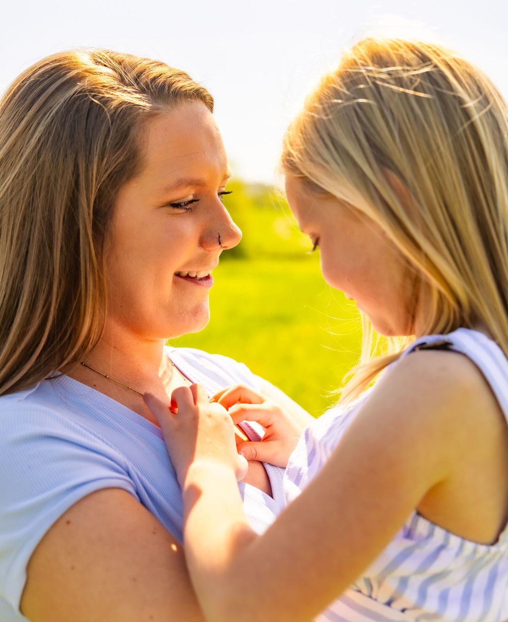 Two people sharing an intimate moment outdoors during golden hour in a natural setting.