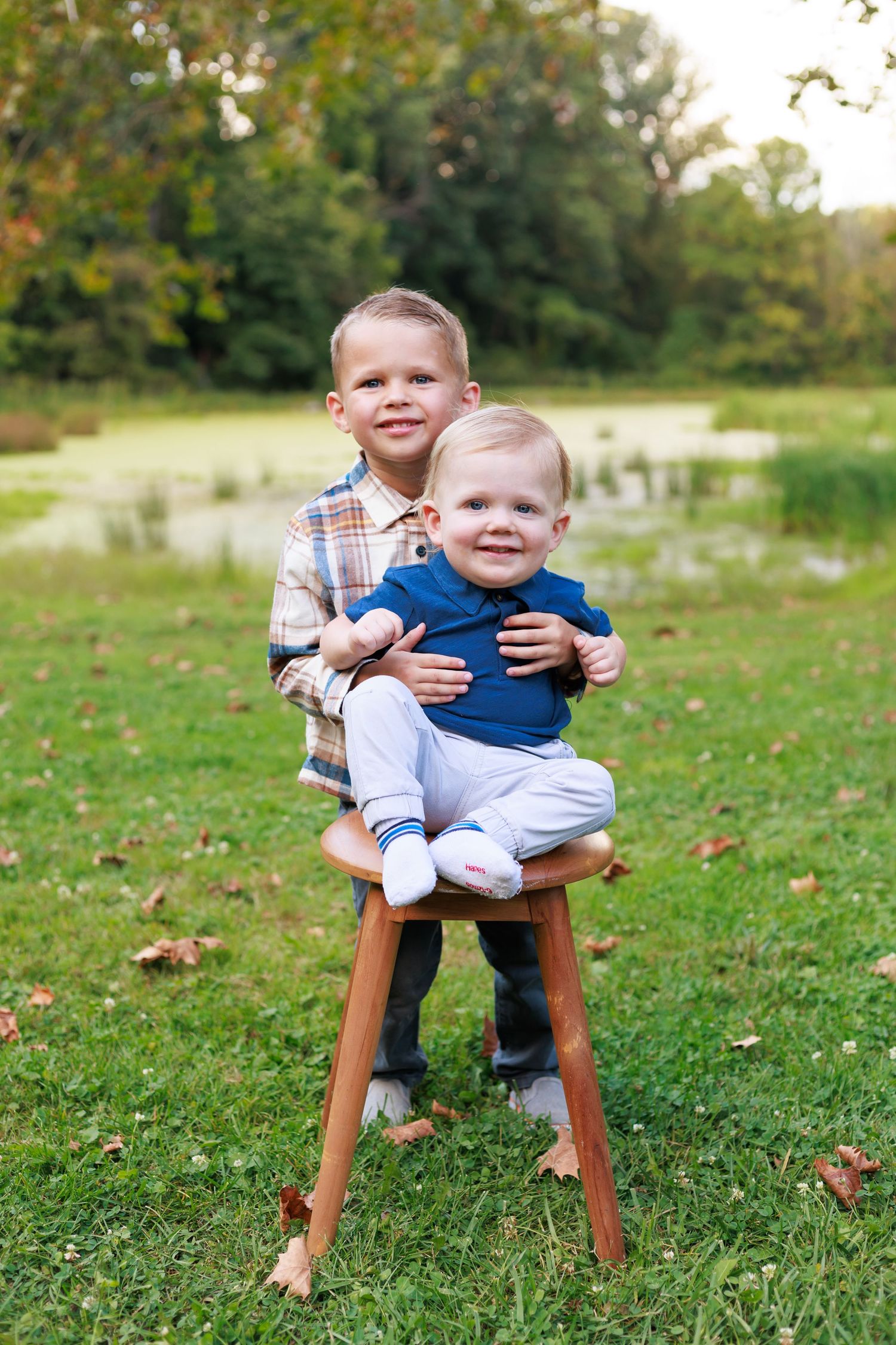 big brother wrapping arms around little brother during golden hour family session in Akron, Ohio