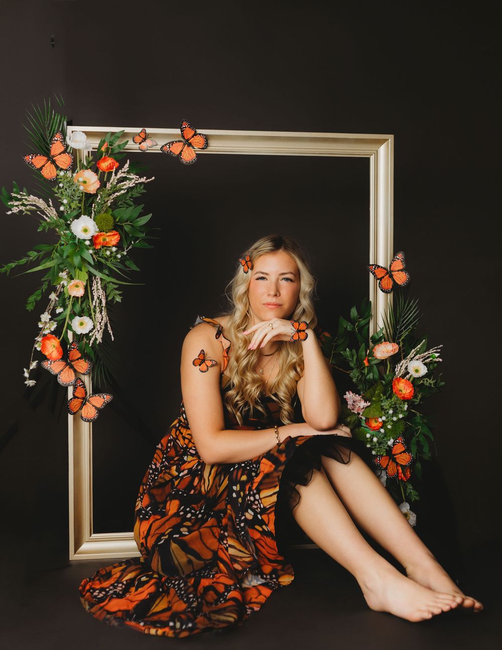 Ethereal butterfly-themed photo with white frame and greenery decorations.