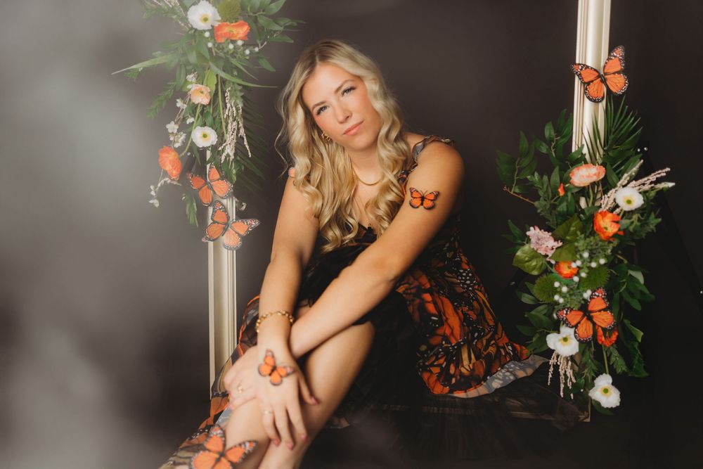 Moody portrait featuring monarch butterfly theme and white picture frame.