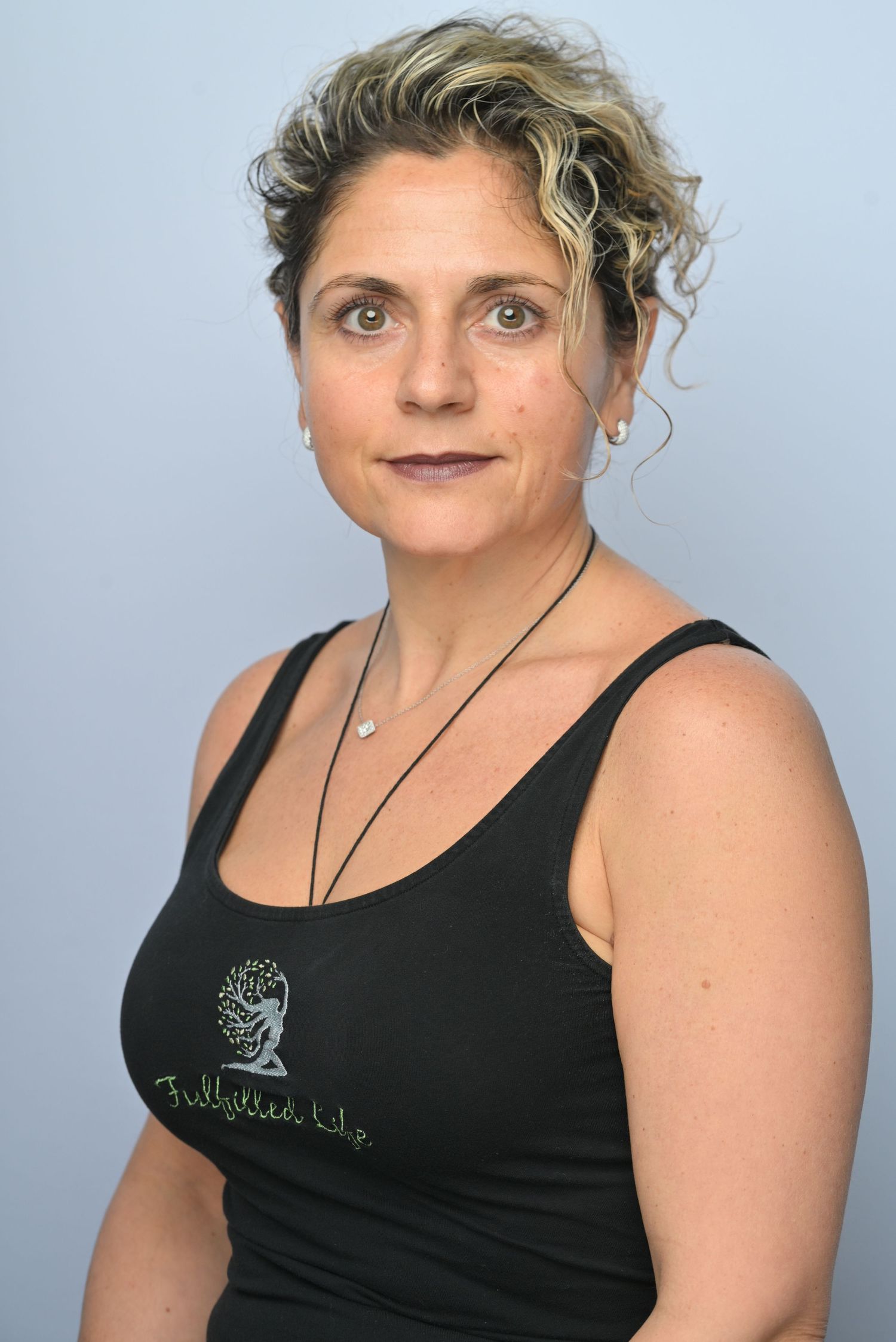 A series of five similar profile shots showing someone wearing a black tank top with a small embroidered design.