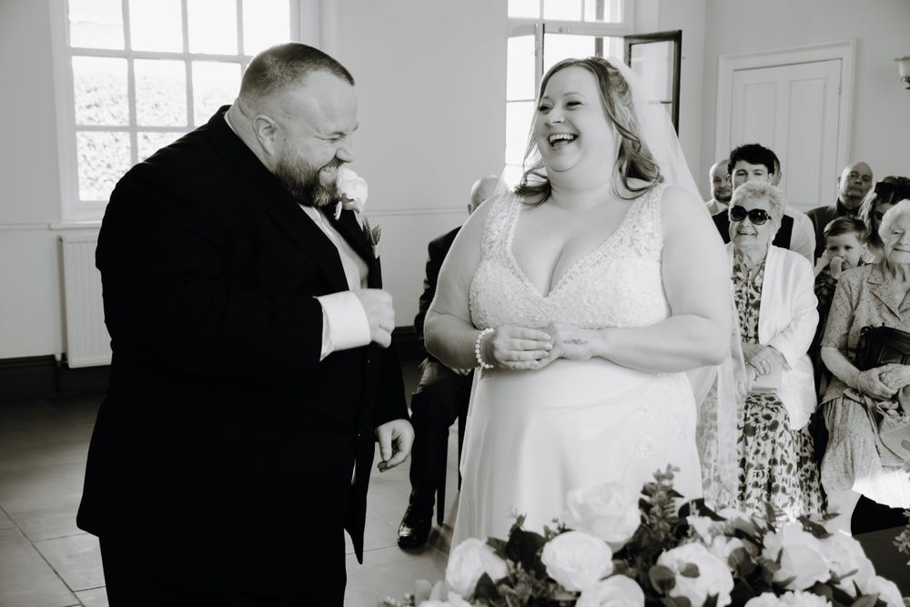 A joyful scene captured during a wedding ceremony as two people share a light-hearted moment together.