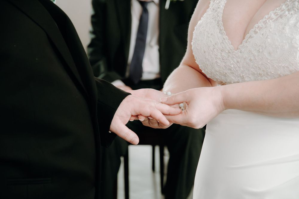 A close-up image of a couple exchanging wedding rings during a traditional ceremony.