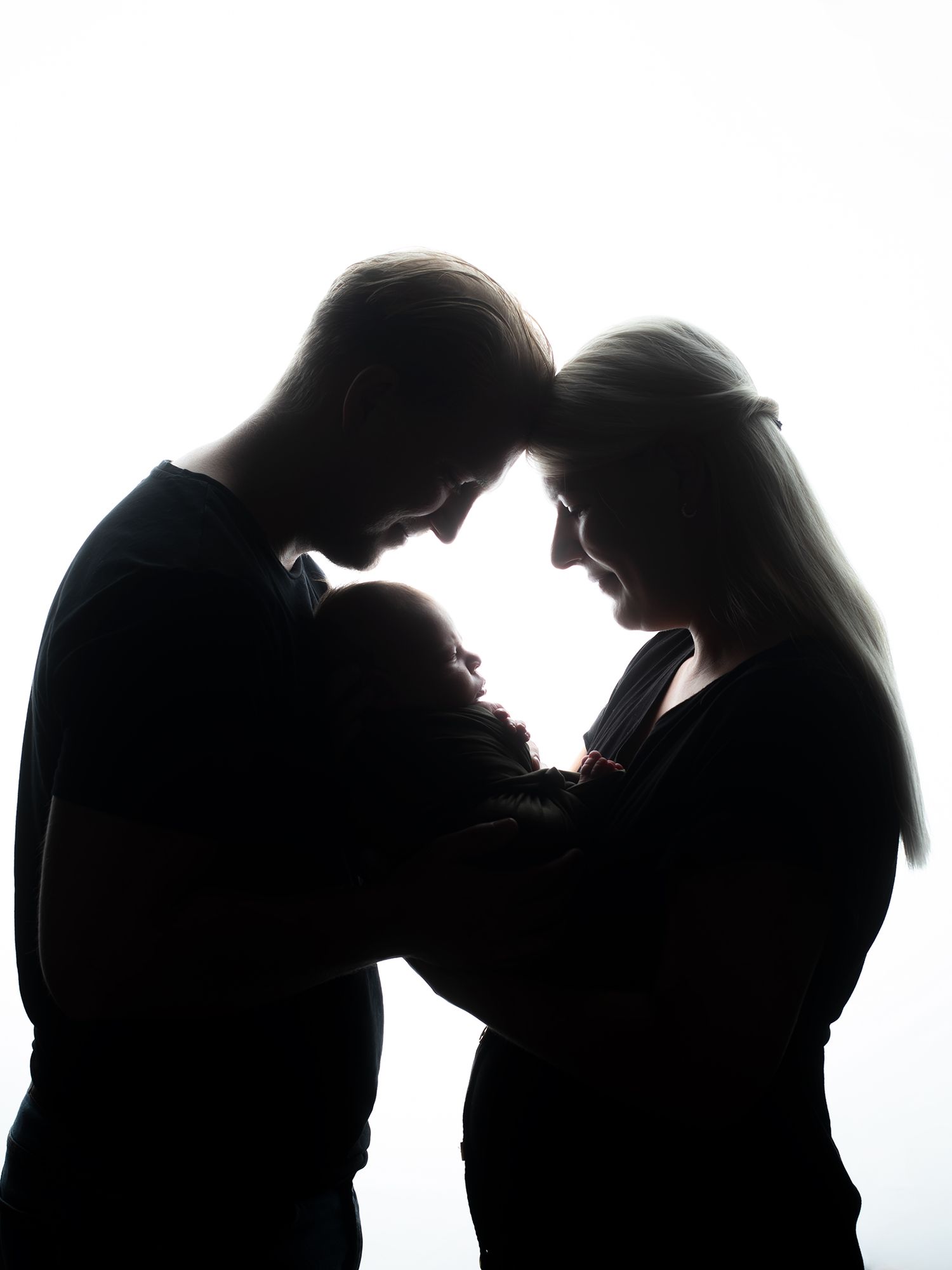 Svartvit familjefotografering i motljus bebis i famnen.Familjefotografering i Västerås, MemoriesbyM